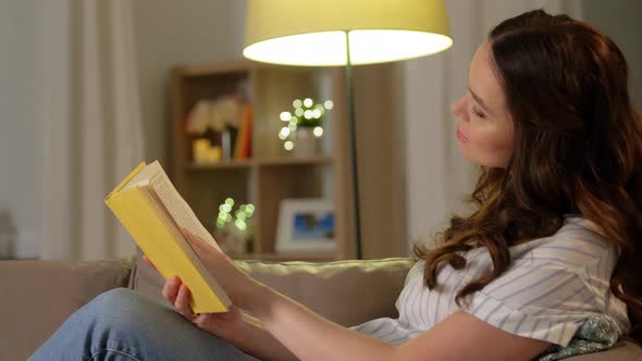 Happy Smiling Pregnant Woman Reading Book at Home