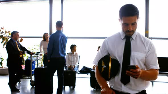 Pilot using mobile phone while commuters interacting with each other