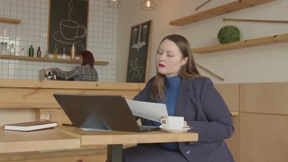 Businesswoman Working Remotely with Client in Cafe