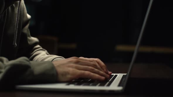 Close-up of Unrecognizable Hacker Man Stretching Hands and Starting To Typing on Laptop Keyboard