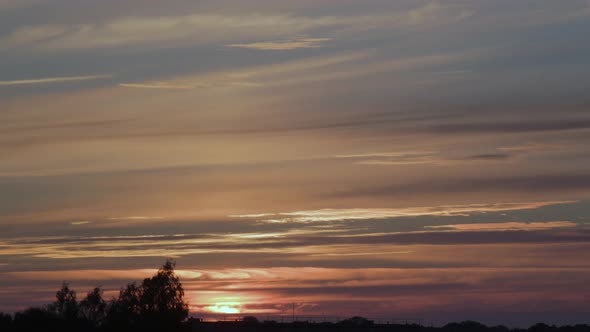 Time lapse of beautiful scenic sunset with clouds and blue sky, wide shot