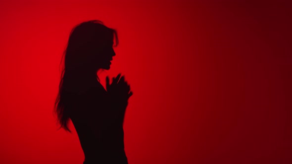 Dark Silhouette of Cheerful Dancing Lady Having Fun Isolated Red Studio