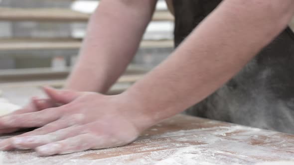 Baker Kneading Dough in a Bakery