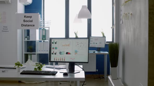 Keep Social Distance Poster on Plastic Separator in Empty Modern Office