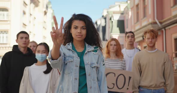 Mixed Race Woman Leader at Multiethnic Protest Shows Peace Gesture