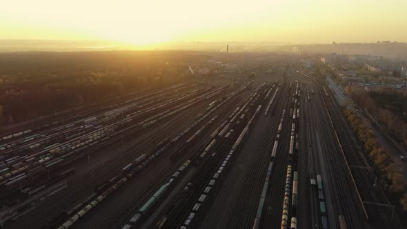 A Drone Camera Rises Above a Railway Sorting Station at Sunset