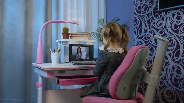 Child Girl Doing School Homework on Laptop Computer at Home with Woman Teacher Distance Education