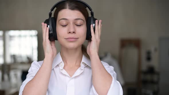 Woman puts on headphones, turns on music, closes her eyes and her mood improves