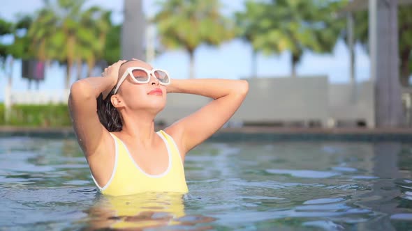 Young asian woman enjoy around outdoor swimming pool for leisure