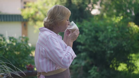 Side View Portrait of Confident Senior Woman Drinking Morning Coffee in Slow Motion Enjoying Leisure