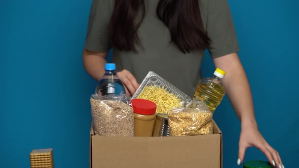 Volunteer Putting Food in a Donation Box. Charity Concept