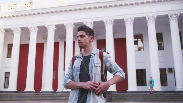 Portrait of Young Attractive Handsome Man Tourist with Backpack in City Center Slow Motion Low Angle