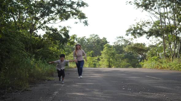 Slow motion, Mother and her son running in the street