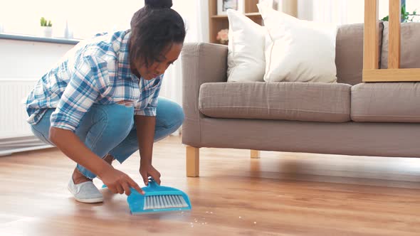 Happy Woman with Brush and Dustpan Sweeping Floor