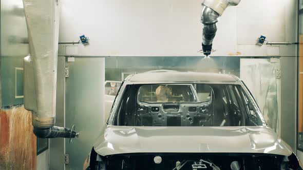 Automotive Painter Robots Painting a Car Body at a Car Factory