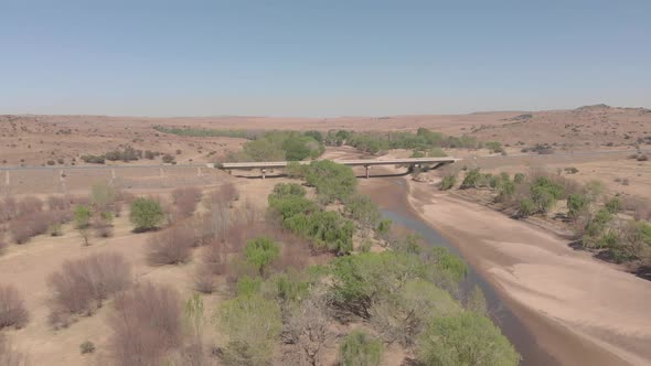 aerial over a dry river with a bridge