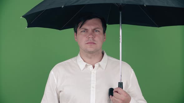 Male caucasian businessman in a shirt with an umbrella.