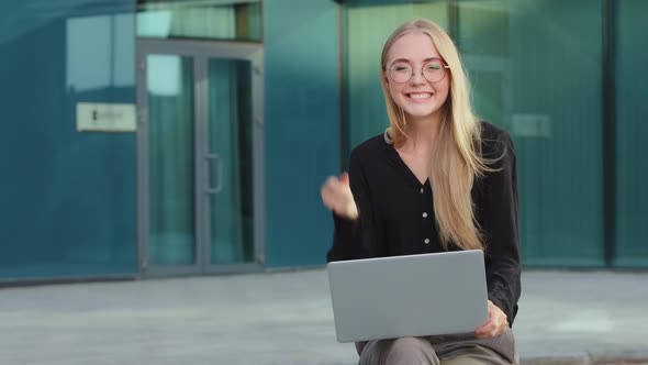 Excited Smiling Millennial Girl in Glasses Sitting Outdoor Triumph Reading Good News Promotion Email