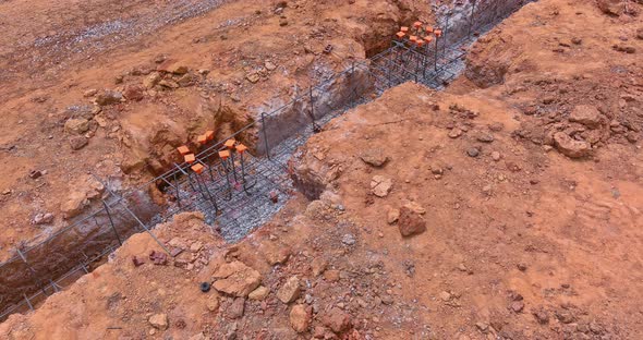 A Construction Site is Being Prepared with Dug Trench Under a Concrete Foundation for a New Home