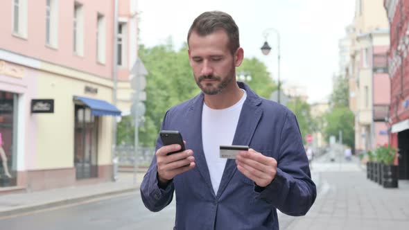 Man Having Online Payment Failure on Smart Phone While Walking Down the Street