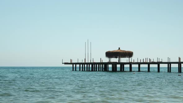 Wooden pontoon in sea, sun rays reflecting in clear sea water surface.