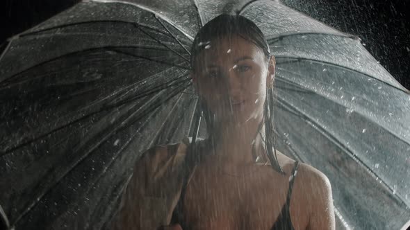 Hot Young Woman Standing Under the Rain and Holding an Umbrella