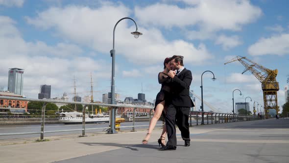 A couple of professional dancers doing a tango coreography in touristic Puerto Madero promenade