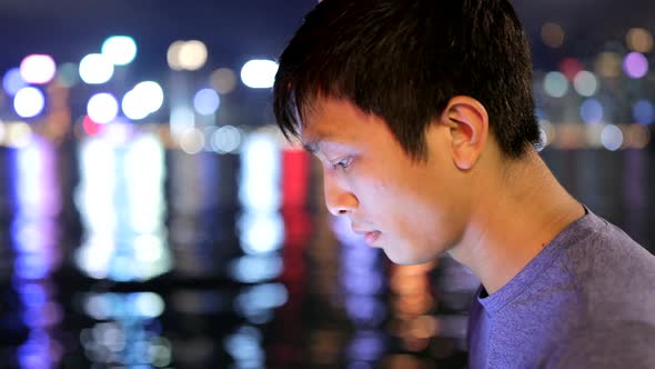 Young man working on tablet computer at night 