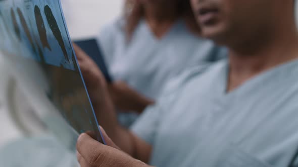 Male Doctor Reading CT Scan and Talking to Tech