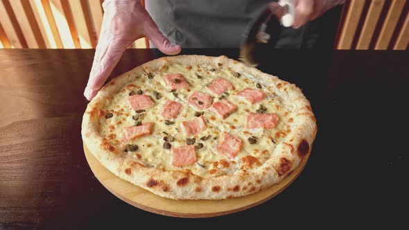 Chef Cuts Freshly Made Pizza with Round Cutter