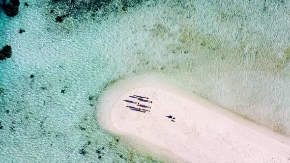 Pulau Katangan sandbank coral reef beach east of Komodo Indonesia with tourists waving arms, Aerial