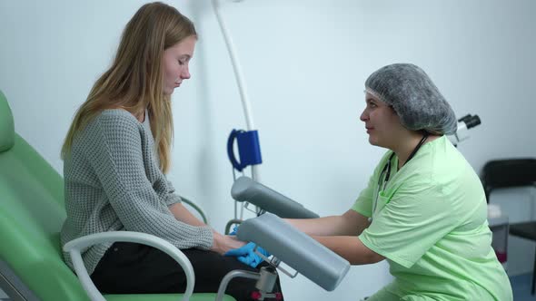 Side View Friendly Gynecologist Holding Hands of Sad Stressed Teenage Patient Sitting on