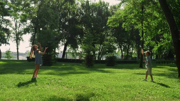 Older Sister Hitting Shuttlecock with Racket