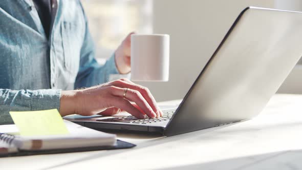 Young male entrepreneur works at home office at the computer.