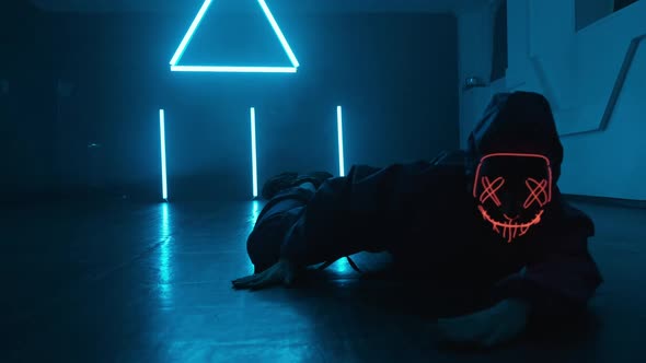 Unknown Person in Neon Mask Enjoying Hip Hop Moves in Dark Studio with Smoke