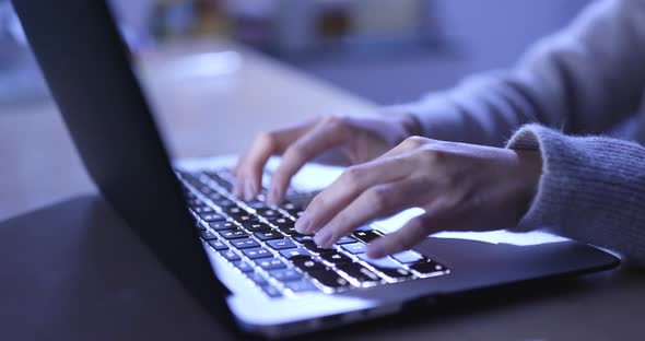 Woman working on notebook computer at night