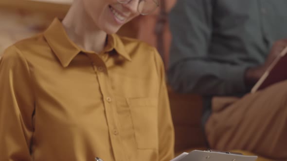 Young Caucasian Woman Writing in Coworking and Smiling