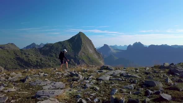 A Girl with a Backpack Travels in the Mountains