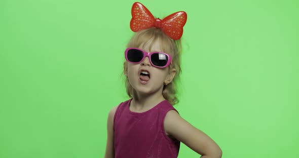 Girl Dancing in Purple Dress, Sunglasses and Red Ribbon on Head. Chroma Key