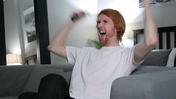 Excited Redhead Man Reacting to Success, Watching TV