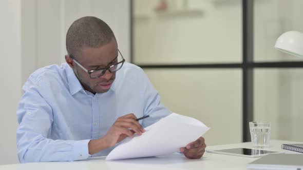 African Man Reading Papers Work