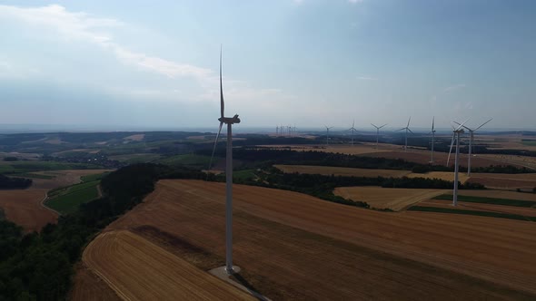 Large Wind Turbines with Blades in Field Aerial View Bright Orange Sunset Blue Sky Wind Park Slow