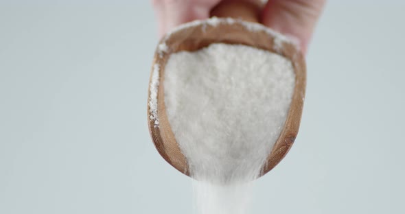 Sugar Is Poured From a Wooden Scoop