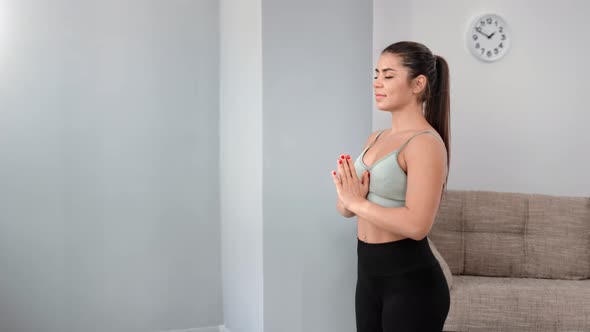 Fitness Woman Practicing Yoga Meditation in Namaste Position Breathing Enjoying Balance Harmony