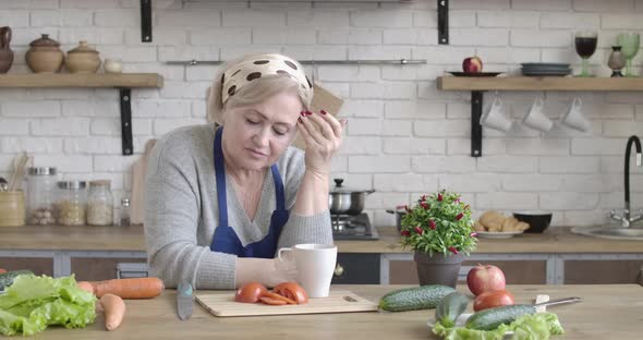 Portrait of Lonely Caucasian Retiree Looking Away As Standing in Modern Kitchen at Home. Depressed