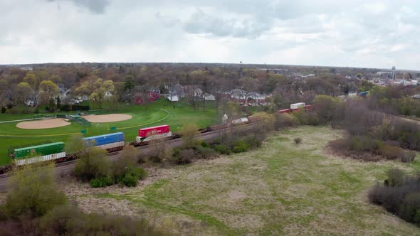 Aerial Drone Shot of Locomotive with Freight Railway Wagon Rides on Railroad