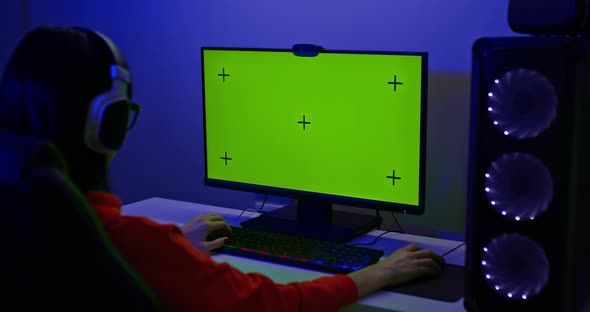 Green Screen of a Powerful Personal Computer a Woman Player is Sitting at a Computer