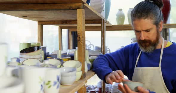 Male potter examining a earthenware bowl