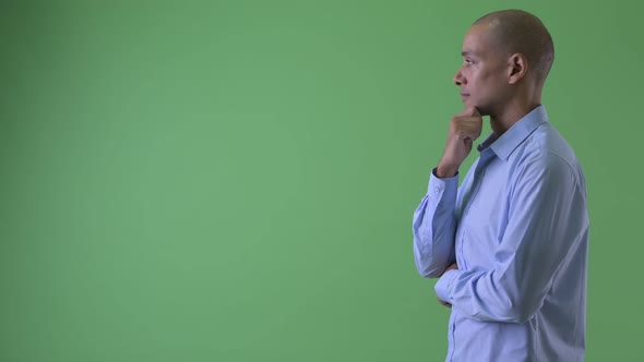 Profile View of Happy Bald Multi Ethnic Businessman Thinking