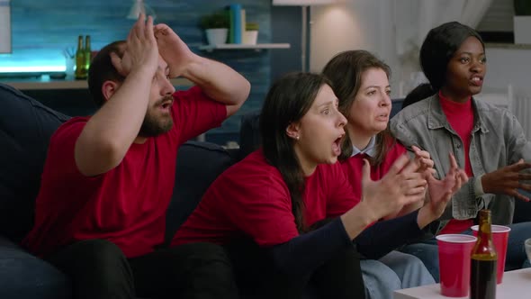 Group of Mixed Race Sport Fans Watching Football Match on Television